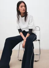 Pantalón de punto azul marino de corte recto y tiro alto, con ribete blanco en los laterales.