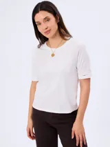 Remera blanca de manga corta 100% algodón, con delicado bordado frontal de diseño botánico y detalles calados en las terminaciones de las mangas.