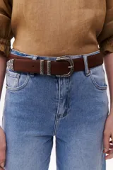 Cinturón marrón de cuero con hebilla metálica plateada con diseño floral.