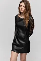 Vestido corto de símil cuero negro, de corte recto, escote amplio y sin mangas, combinado con mangas largas de encaje negro.