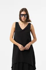 Vestido largo color tostado con silueta relajada, escote en V, sin mangas y diseño de falda en capas. Cuenta con un lazo fino regulable en la cintura.