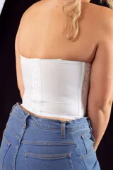 Corset blanco de puntilla con forro de tul, media copa con aro, breteles regulables desmontables y ganchos reforzados en la espalda.