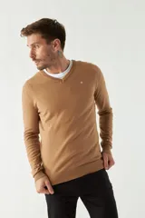 Sweater de punto color rosa con cuello en V y logo bordado en el pecho.