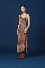 Vestido midi de tirantes con escote drapeado y espalda descubierta. Presenta un estampado abstracto en tonos tierra y una caída fluida.