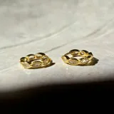Par de aros tipo huggies de plata 925 con acabado en oro de 18k y circonitas engarzadas. Diámetro de 10 mm.