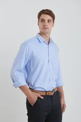 Camisa celeste de vestir, de manga larga, con cuello clásico y bolsillo en el pecho.