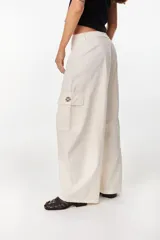 Pantalón cargo color beige de tiro bajo y corte ancho, con bolsillos laterales utilitarios.