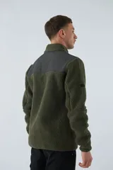 Campera de sherpa para hombre, color azul marino con detalles en marrón. Tiene cuello alto, cierre frontal y bolsillos laterales con cierre.