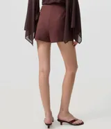Short pollera corto color marrón de bengalina, con diseño cruzado en el frente, cierre invisible en la parte trasera y talle alto.