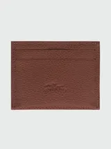 Tarjetero de cuero granulado color caramelo, con múltiples ranuras para tarjetas. Presenta el logo de Longchamp grabado en el centro.