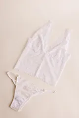 Topcito tipo bralette de encaje negro con escote en V profundo y tirantes anchos. El encaje es elastizado para un ajuste cómodo.