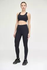 Calza larga negra de tiro alto, confeccionada en tejido de poliamida y elastano.