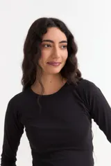 Remera de manga larga con cuello redondo a la base, confeccionada en algodón suave de corte ajustado.