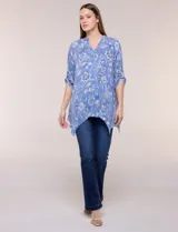 Blusa azul con estampado floral, escote en V, abotonadura frontal y mangas tres cuartos con presilla para arremangar. Cuenta con un diseño amplio y ruedo asimétrico en punta.