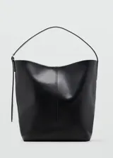 Bolso shopper de cuero color negro, de gran tamaño, con costura central vertical, asa de hombro ajustable y cierre de botón magnético.