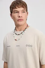 Remera oversize de color azul marino, de manga corta y cuello redondo. Presenta un diseño estampado en la espalda con la inscripción "Boundless Art", un gráfico circular abstracto y textos adicionales.