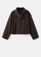 Chaqueta marrón de corte recto y diseño crop, confeccionada en mezcla de algodón y poliamida con forro interior de poliéster. Presenta cuello alto tipo embudo, doble botonadura frontal, manga larga y dos bolsillos laterales.