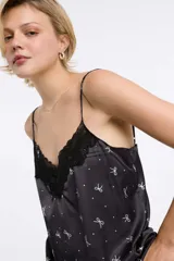 Musculosa de viscosa satinada con estampado animal print en tonos negro, blanco y verde oliva. Presenta tirantes finos regulables y escote en V con detalle de encaje negro.