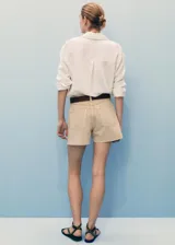 Short de jean de tiro medio, color beige, con diseño de cinco bolsillos, corte recto y bajo deshilachado.