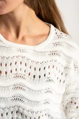 Sweater de punto calado con diseño de ondas horizontales, cuello redondo y mangas largas. Presenta un corte oversize y acabado en color blanco.