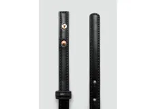 Cinturón fino de poliuretano color negro, con elegante hebilla metálica dorada.