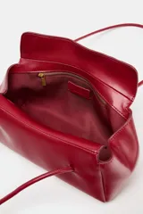 Bolso de hombro en formato alargado de diseño minimalista, con doble asa larga y cierre imantado. Cuenta con un bolsillo interior con cremallera.