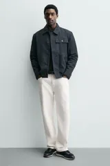 Zapatilla deportiva color verde militar, con parte superior de múltiples piezas que combinan piel y serraje. Presenta horma redonda y suela dentada en color crema con base marrón.