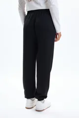 Pantalón deportivo negro de corte holgado con puños ajustados en los tobillos y cordón de ajuste en la cintura.