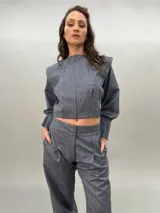 Campera corta de lana y seda color gris con cierre frontal oculto y mangas largas con diseño de tablas en los puños.