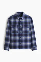 Sobrecamisa de franela suave con cuello inglés, tapeta lisa y bolsillos superiores con solapa. Presenta mangas largas con puños abotonados, canesú en la espalda y bajo recto.