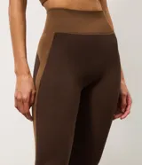 Pantalón legging deportivo Get Over de tiro alto, confeccionado en microfibra seamless de color marrón con detalles laterales en tono tostado y cintura ancha acanalada.