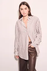 Camisa oversize a rayas verticales color beige y blanco, de mangas largas y corte holgado.