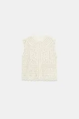 Blusa sin mangas confeccionada en tejido tipo crochet con diseño geométrico calado, cuello redondo y cierre frontal con botones.