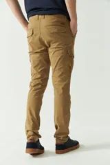 Pantalón cargo azul marino para hombre, con bolsillos laterales y traseros con solapa, cierre con cremallera y botón, trabillas para cinturón y logo en grifa de cuero. Confeccionado en algodón y spandex.