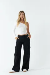 Top asimétrico de una sola manga larga, color azul, con jaretas ajustables en ambos laterales del torso que permiten regular el largo de la prenda.