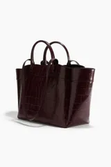 Bolso tipo shopper de cuero sintético con textura de cocodrilo en tono borgoña oscuro. Presenta dos asas de mano cortas y dos asas de hombro largas. La parte superior tiene un borde ondulado.