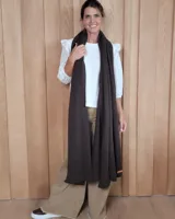 Bufandón de lana lambswool, de textura suave y liviana, con diseño liso y etiqueta de cuero en el extremo inferior.