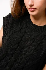 Chaleco negro de lana con cuello redondo y diseño trenzado.