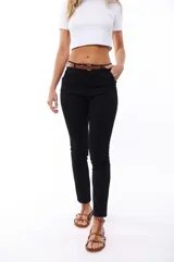 Pantalón negro de corte ajustado, con cinturón fino marrón.