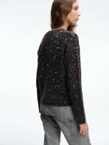 Sweater de punto con escote en V, manga larga y diseño holgado. Presenta un estampado animal print con aplicaciones de lentejuelas brillantes en tonos oscuros.