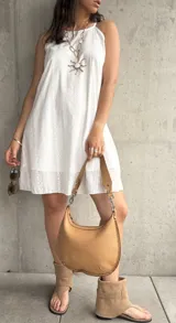 Vestido corto blanco con bordado calado, tirantes finos y corte recto.
