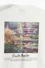 Remera blanca de corte holgado, con cuello redondo y diseño de manga corta. Presenta un pequeño estampado con la firma de Claude Monet en el pecho.
