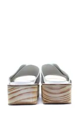 Zueco con plataforma de madera y capellada de cuero negro con textura croco.