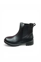 Bota de caña baja tipo Chelsea color negro, con elásticos laterales, suela track y taco bajo.