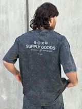 Remera gris con efecto gastado, corte oversize, mangas cortas y estampado en la espalda con el texto "SUPPLY GOODS DESIGNED IN PUNTA DEL ESTE".