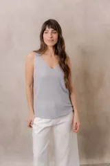 Musculosa de punto negro con efecto brillante, calce al cuerpo, escote en V y tirantes anchos.