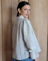 Blusa de algodón con cuello mao y volados, mangas largas con puños elásticos y corte holgado.