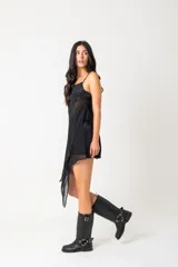 Borcegos de caña alta (30 cm) color negro, confeccionados en ecocuero, con suela gruesa y bajo relieve. Presentan una correa con hebilla metálica plateada alrededor del tobillo y una correa ajustable con hebilla en la caña superior.