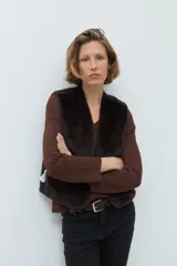 Chaleco reversible de corte recto, con un lado de cuero sintético color chocolate y el otro lado de piel sintética al tono. Presenta cuello redondo y diseño sin mangas.