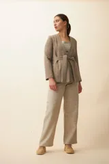 Chaqueta corta color beige, entallada, con escote en V, manga larga y bolsillos escondidos. Cierre frontal con lazo fijo. Confeccionada en lana fina sin teñir. Diseño exclusivo de Don Baez.